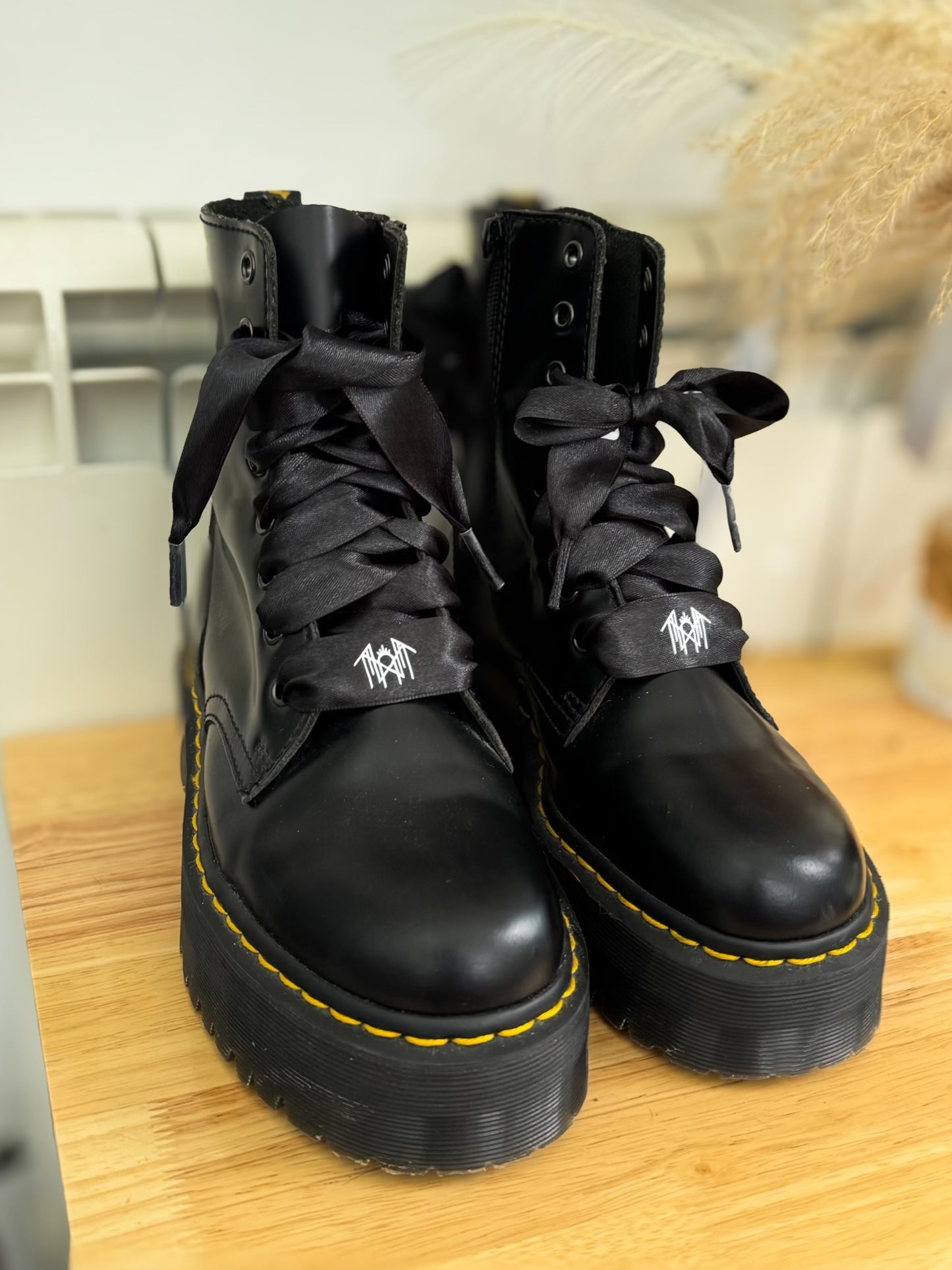 Pair of Jadon Dr. Martens boots laced with black satin ribbon shoelaces printed with white Sleep Token logos, displayed on a clean background.