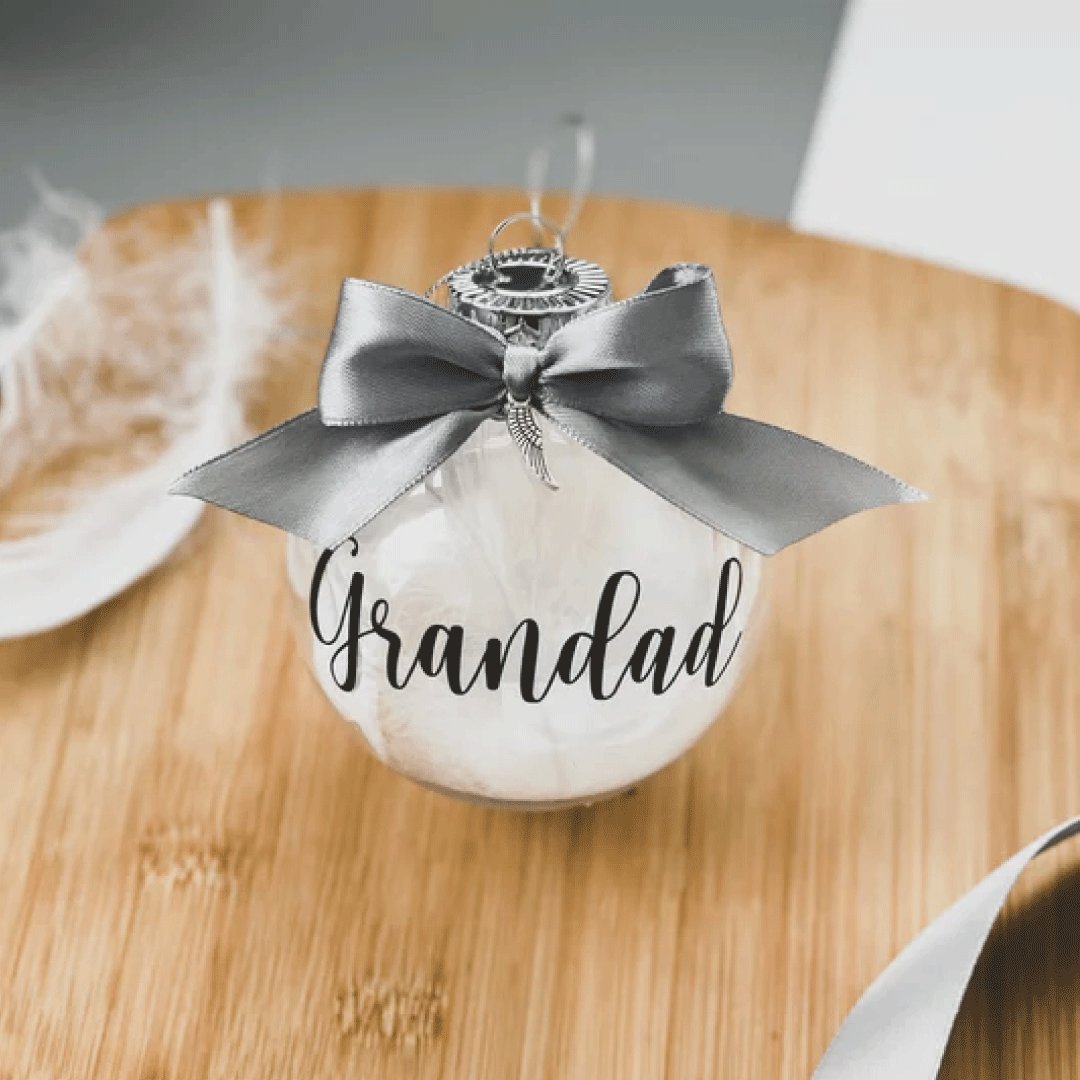 Personalised Memorial Bauble filled with white feathers and a topped with a silver bow including a silver wing charm 