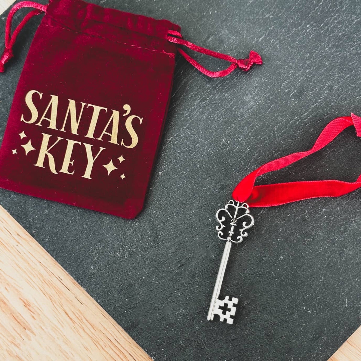 Santa's Key velvet bag beside a silver key on a red ribbon