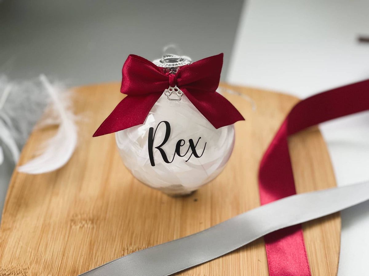 Pet memorial bauble personalised with the name Rex and a red bow