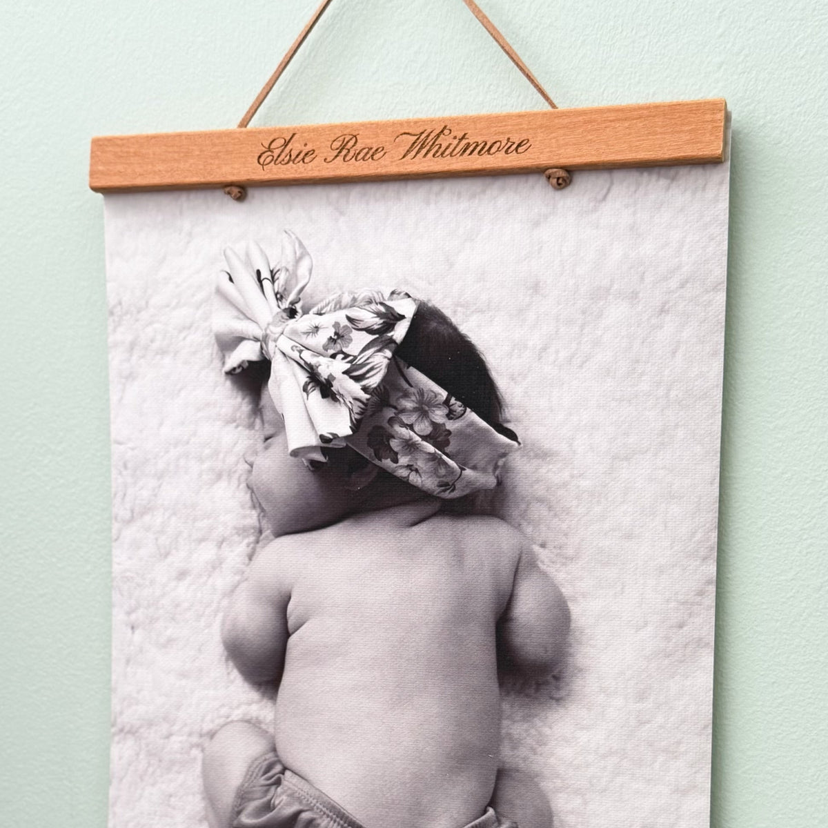 Black and white photo of a baby in a engraved wooden frame 