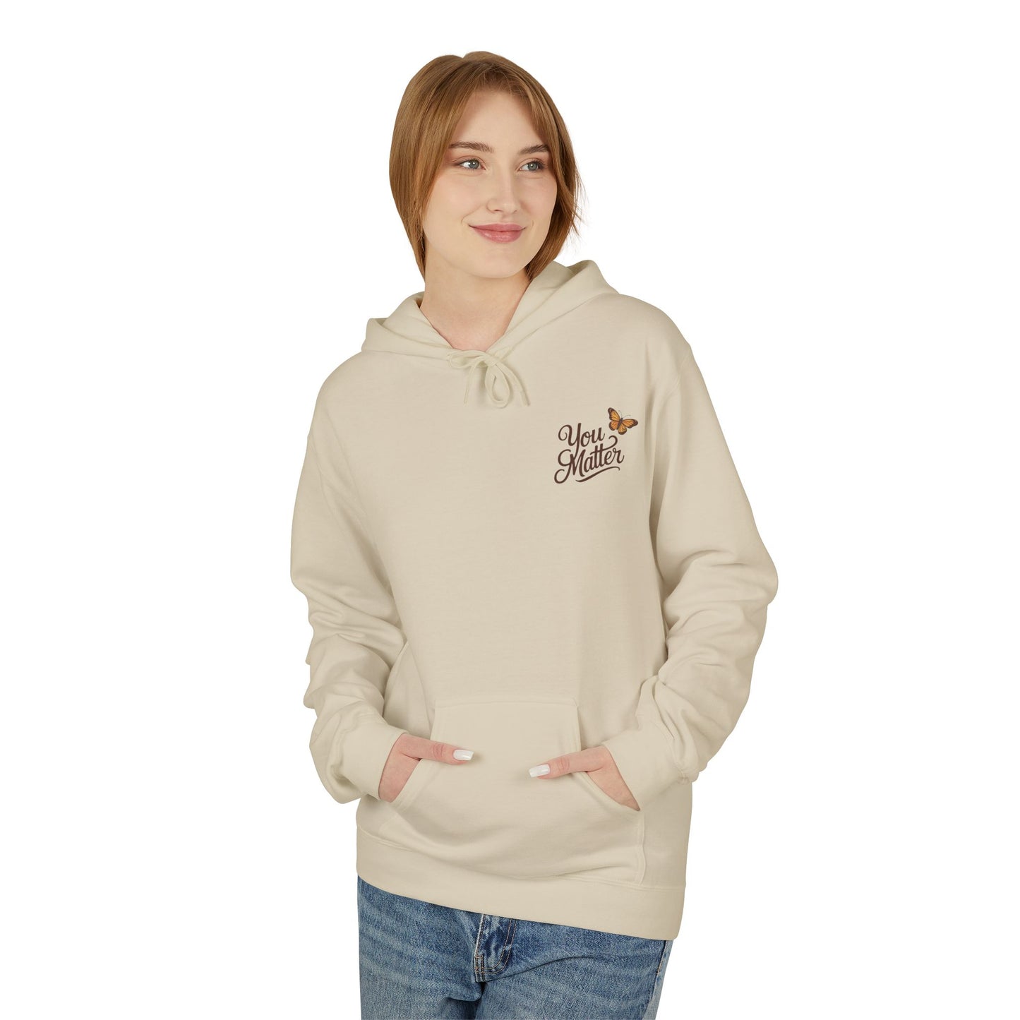 Person wearing a beige hoodie with text and a logo on a white background