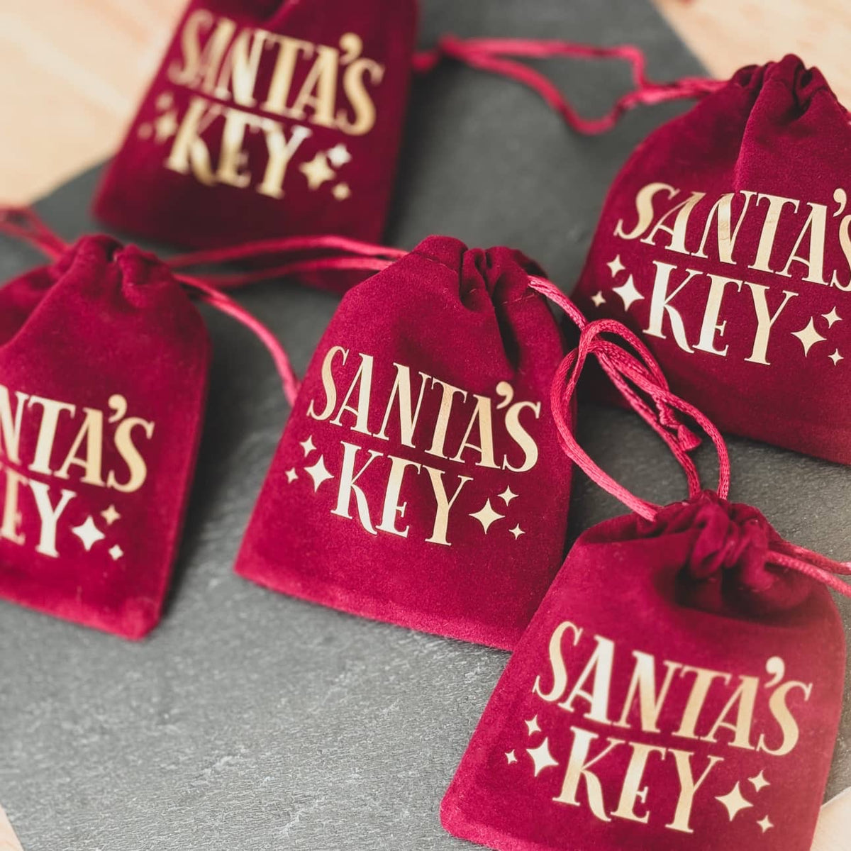 Group of red velvet bags printed with Santa's Key in gold