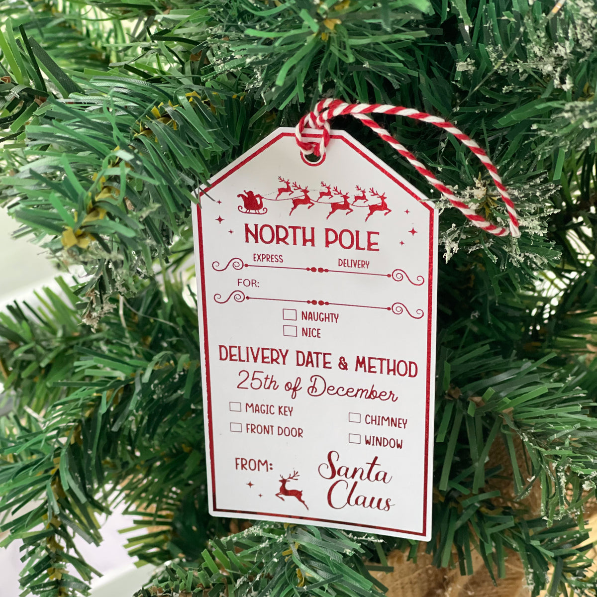 North Pole Santa gift tag hanging on a Christmas tree