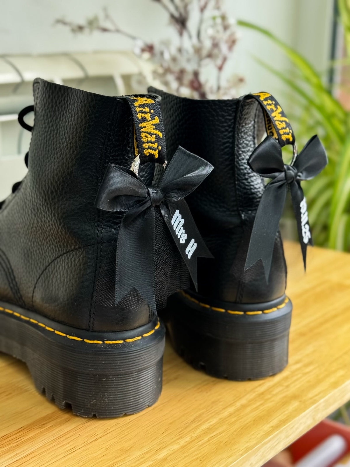 Black boots with black bows on a wooden surface