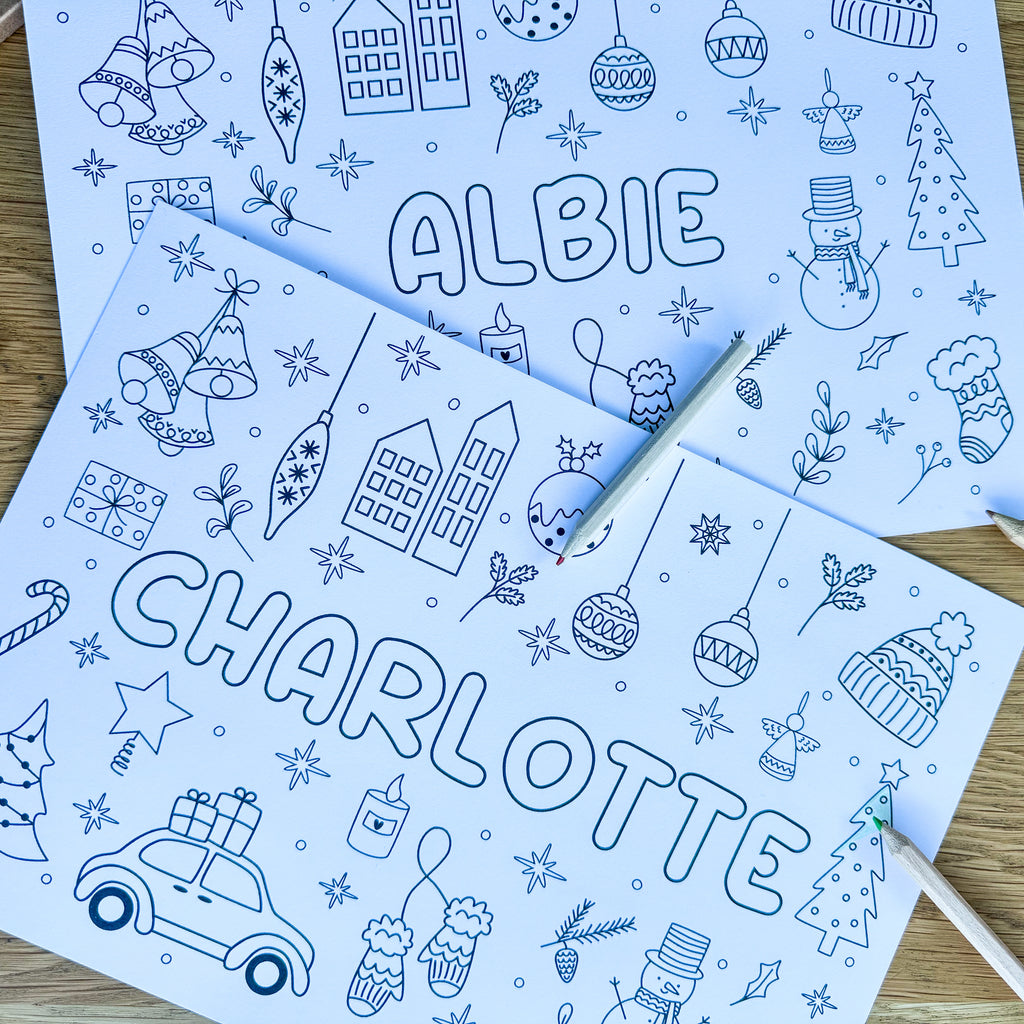 Two personalised Christmas colouring placemats for Albie and Charlotte with a pen
