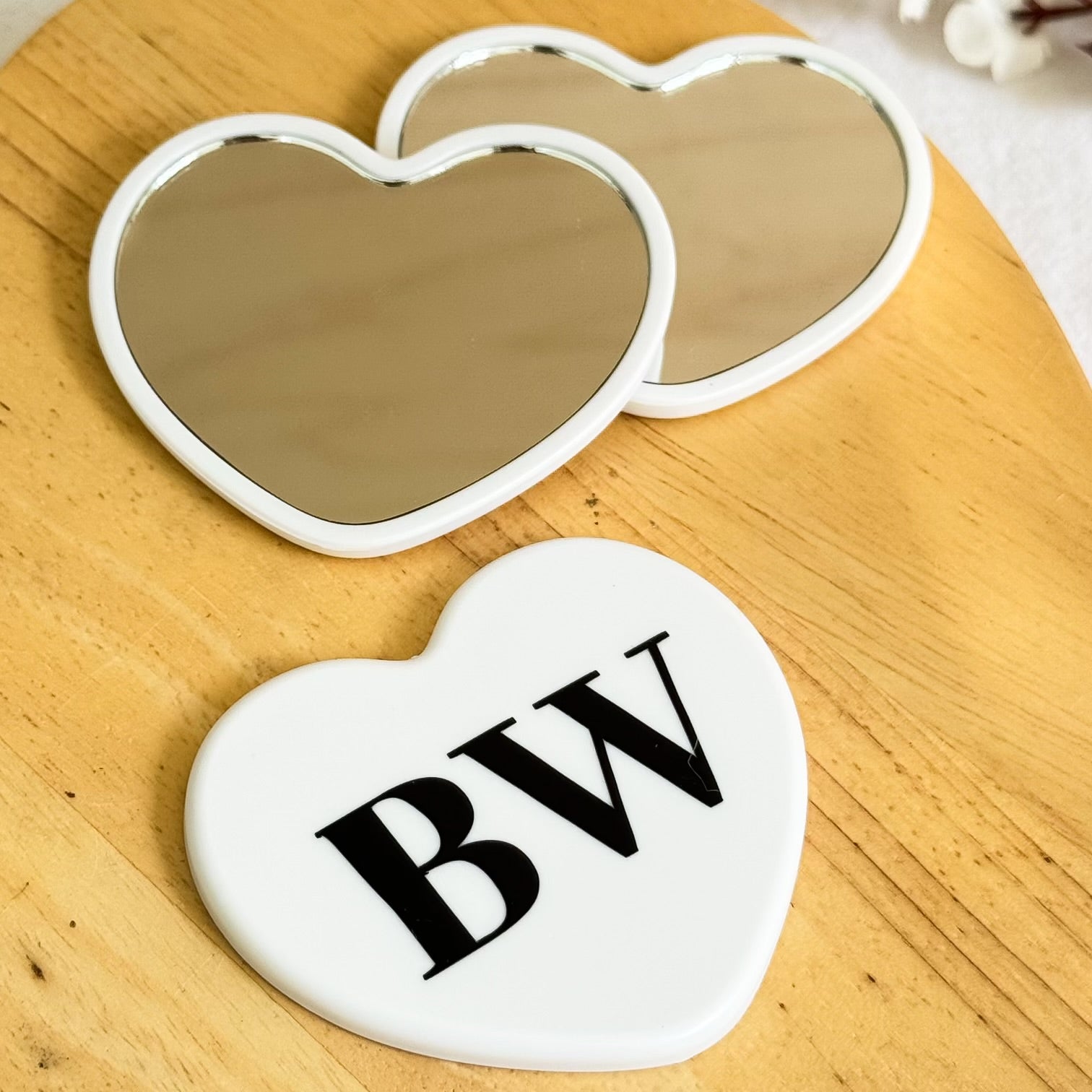 Set of mini heart-shaped personalized mirrors with initials ‘BW’ on wooden surface