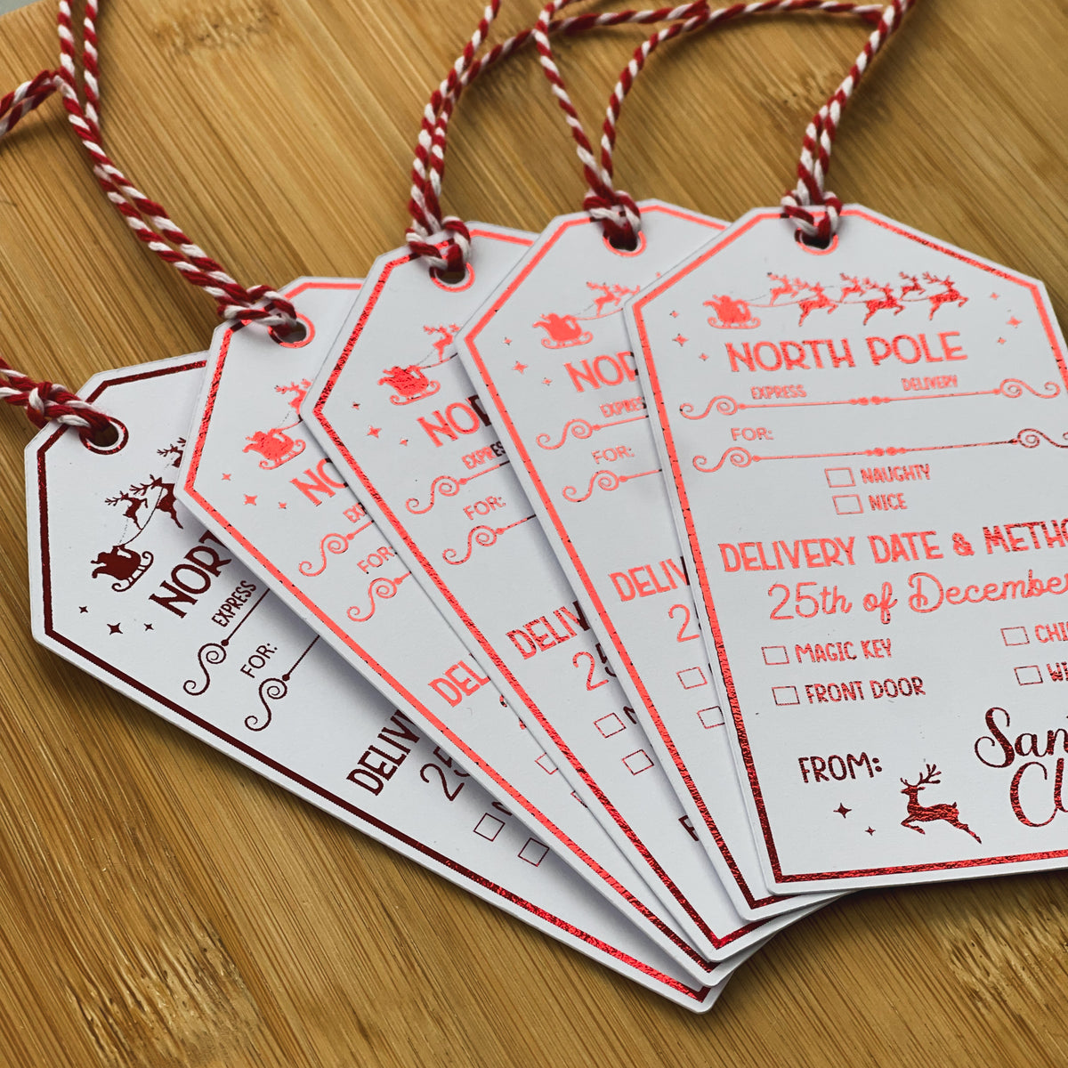 North Pole delivery gift tags tied with red and white string
