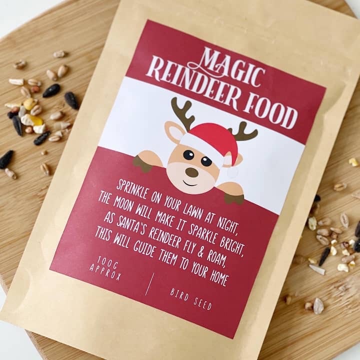 Magic Reindeer Food pouch with oats and seeds scattered on a wooden board