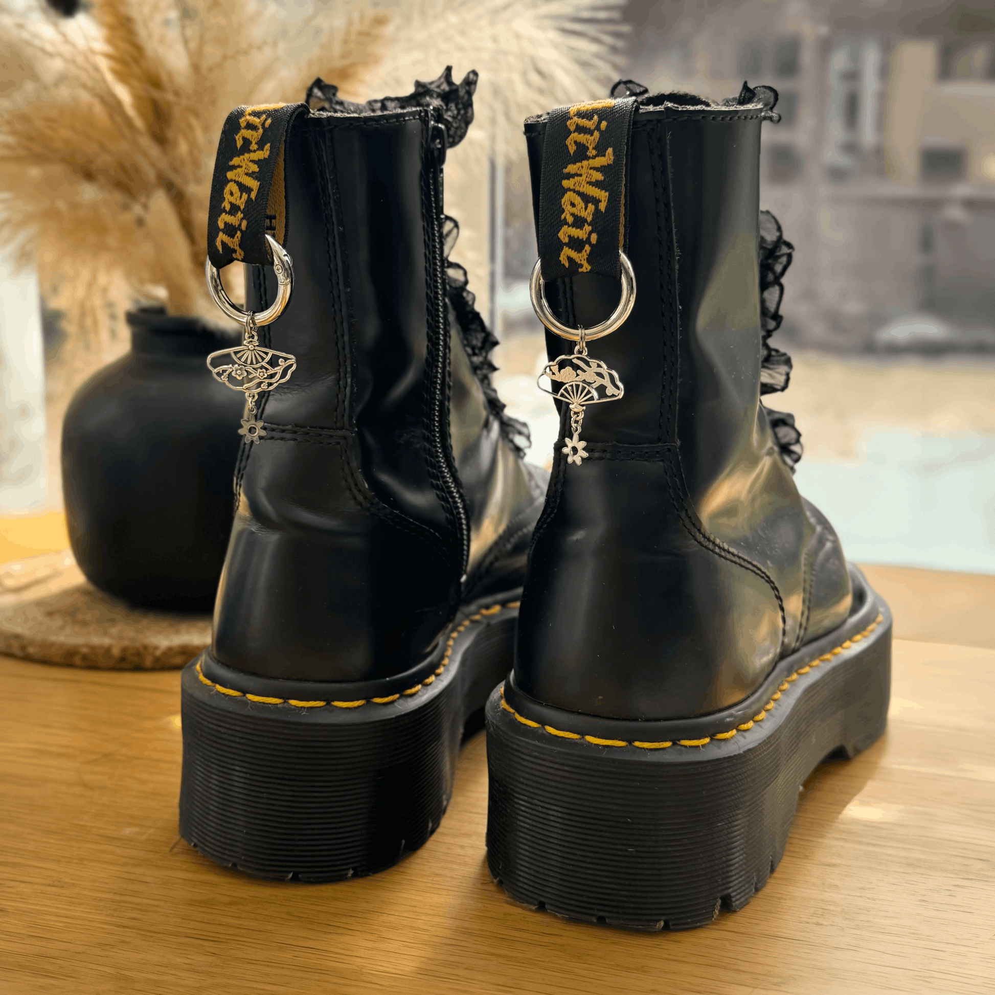 Black leather boots with decorative elements on a wooden surface