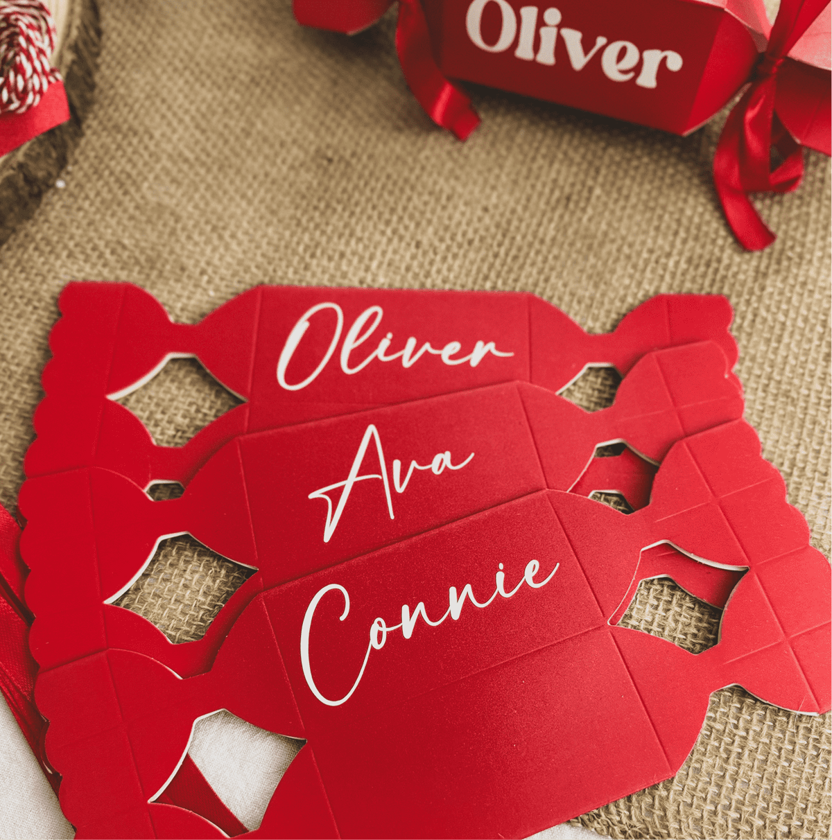 Flat red cracker templates personalised with the names Oliver, Ava and Connie