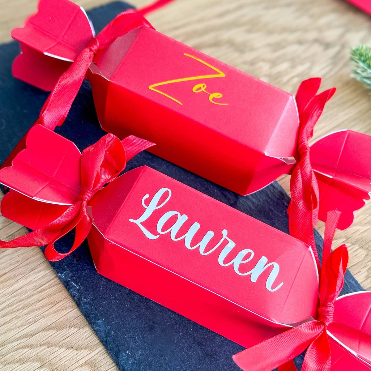 Two personalised red Christmas crackers with the names Zoe and Lauren