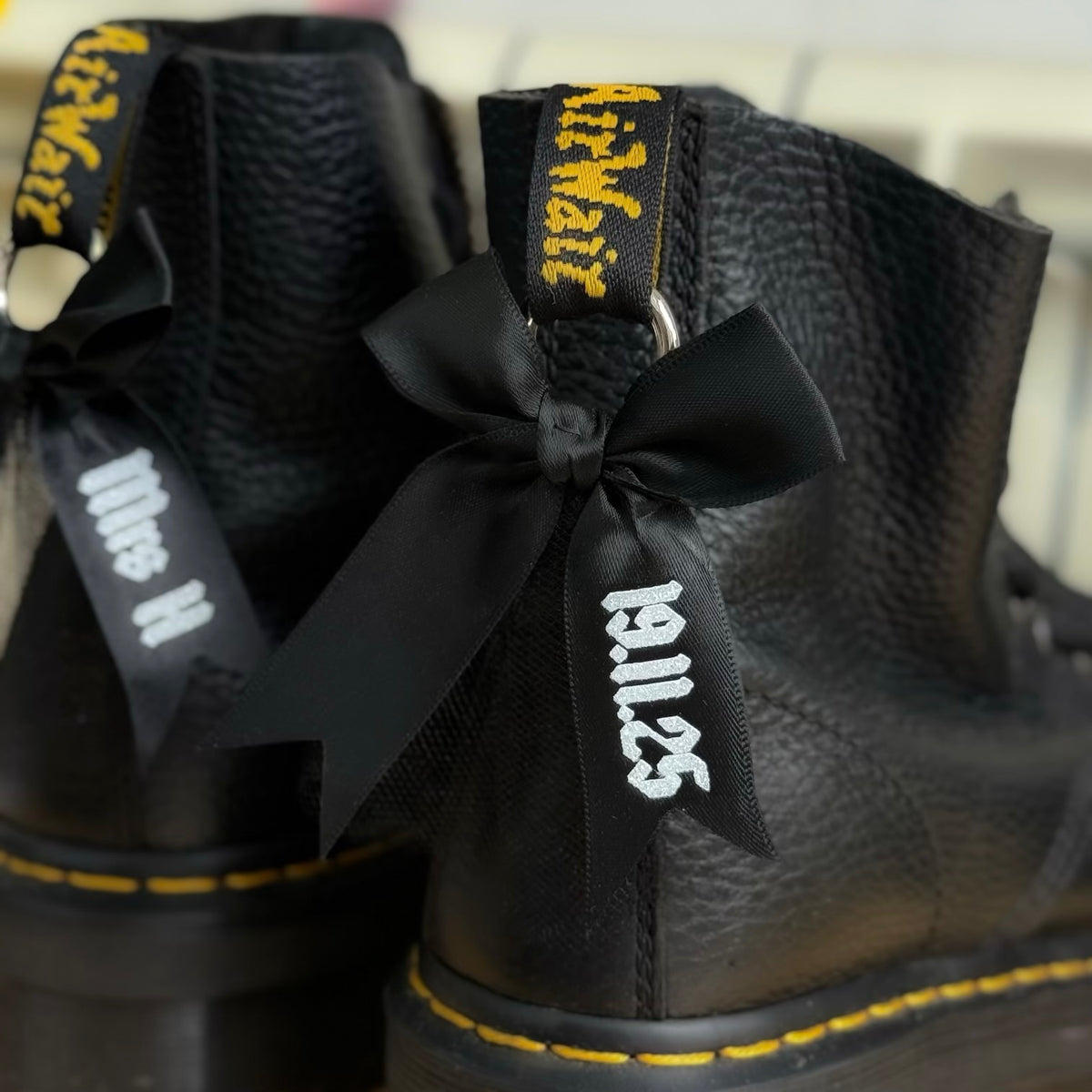 Black boots with a black bow wotj wedding date text branding on 