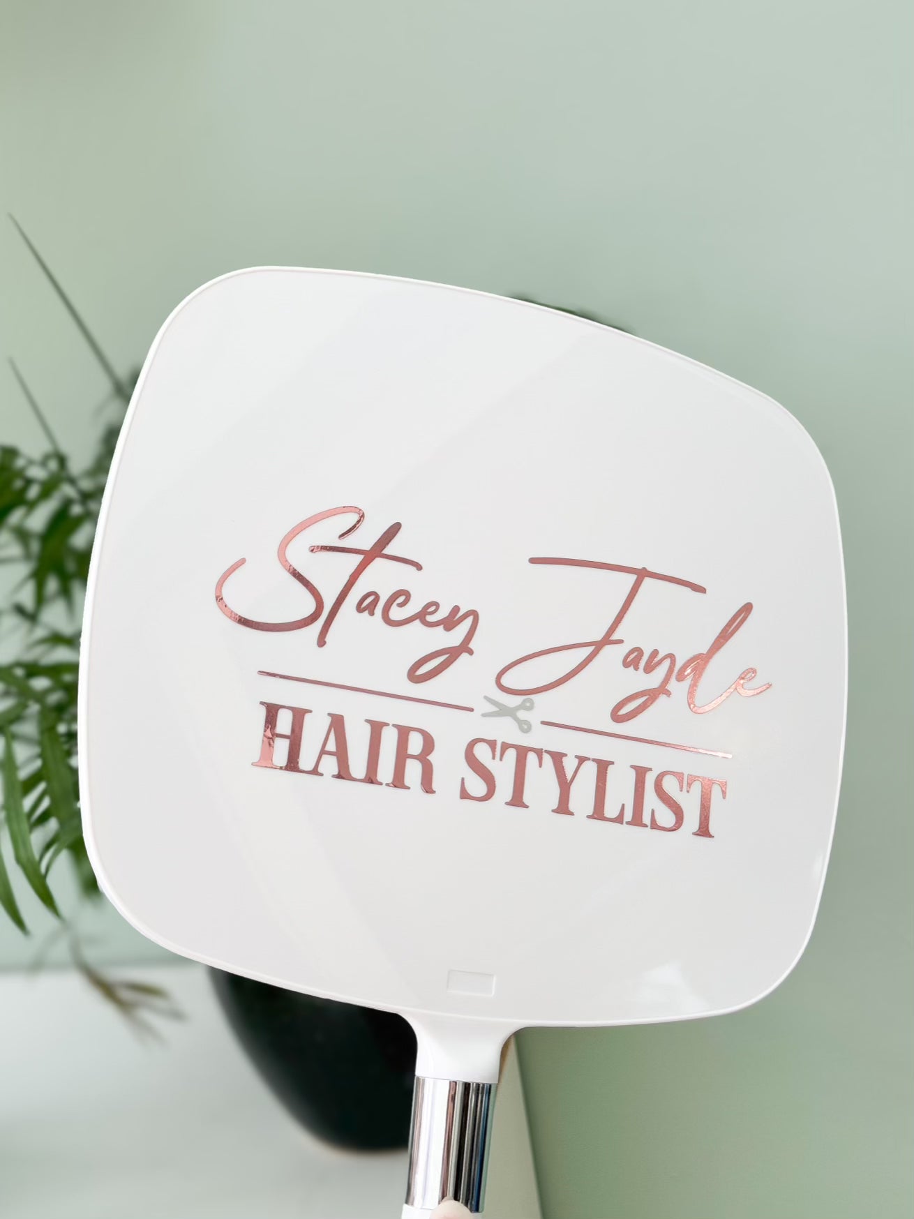 White paddle brush with 'Stacey Jayde Hair Stylist' text on a light green background