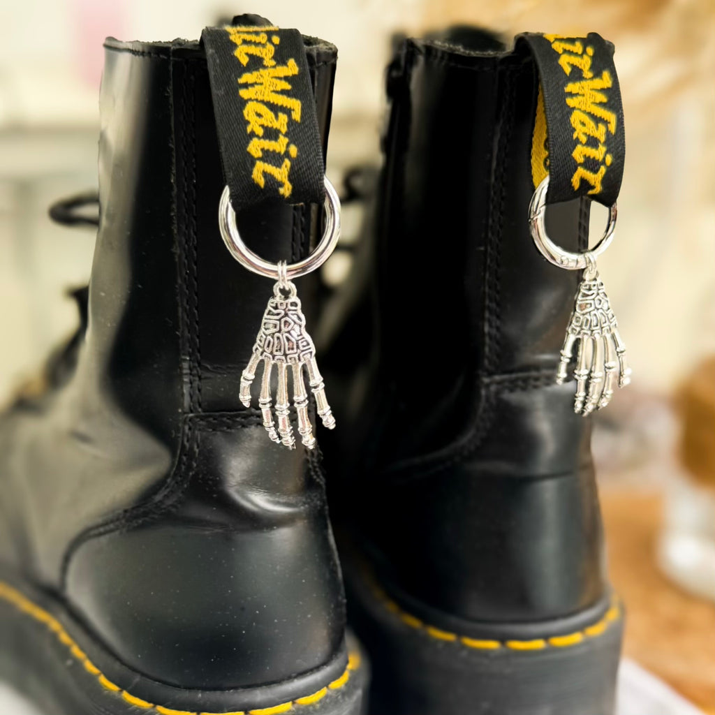 Black boots with decorative skeleton hand charms for dr martens boots