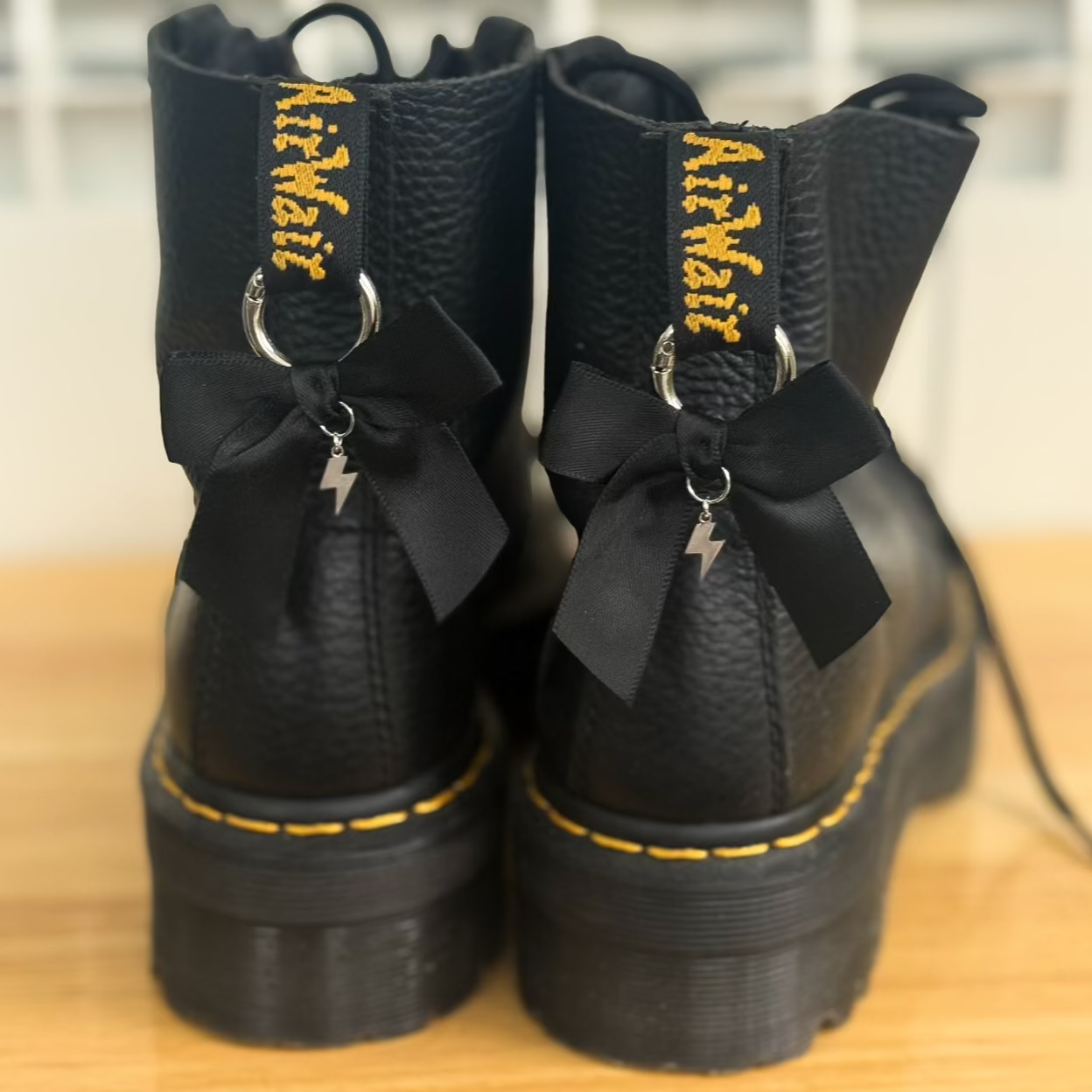Black boots with black bows and lightening bolt charms