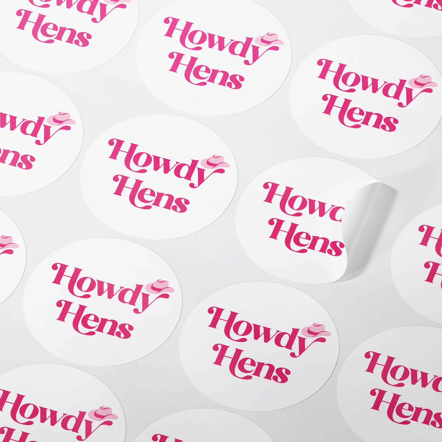 Round white stickers with pink 'Howdy Hens' text written in a fun, retro font, featuring a pink cowboy hat illustration. Available in glossy and matte finishes, the stickers come in two sizes: 32mm (35 stickers per sheet) and 37mm (24 stickers per sheet). Perfect for decorating invitations, envelope seals, and party favors for a cowboy-themed hen party.